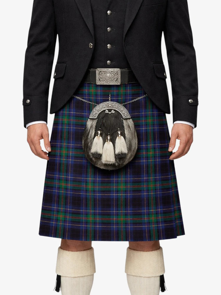Person wearing a traditional Scottish kilt with a jacket and white shoes on a white background