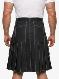 Person wearing a black pleated kilt on a white background