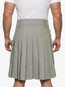 Person wearing a gray pleated kilt on a white background