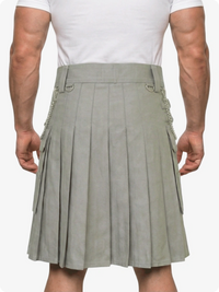 Person wearing a gray pleated kilt on a white background